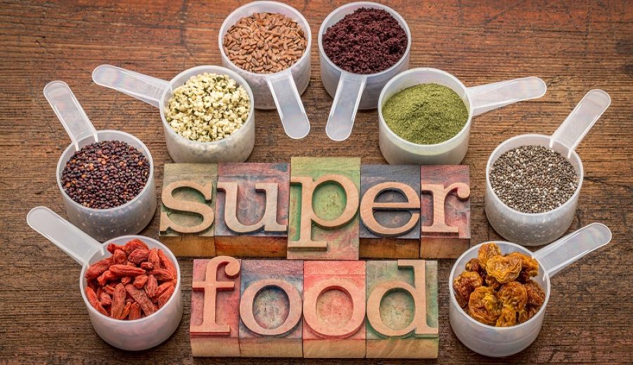 superfood abstract (wheatgrass, acai berry, goji berry, falx seed,chia seed,goldenberry,hemp seed, quinoa grain) - a set of measuring scoops with la letterpress text against rustic wood